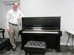 Picarzo Pianos Michael Pratt next to Steinway Upright Piano